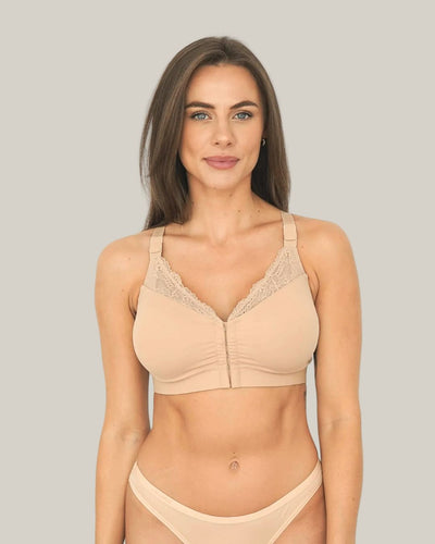 Woman wearing a beige bra and panties set against a plain background